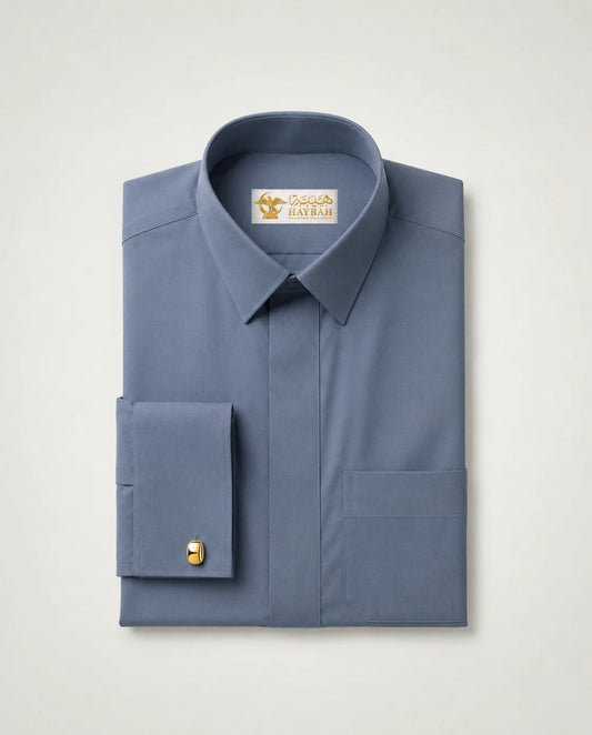 Folded Slate Blue Luxury Thobe showcasing premium slate blue fabric, concealed placket, luxury craftsmanship, structured collar, elegant cuff detailing, and sophisticated Gulf formalwear design by Haybah. ثوب أزرق رمادي فاخر مطوي بعناية يبرز جودة القماش الفاخرة والتفصيل الراقي المناسب للمناسبات الرسمية والاحتفالات الراقية.