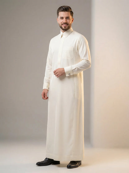Cream White Luxury Thobe – Ceremony Edition by Haybah featuring a refined cream white tone, concealed front placket, structured collar, premium luxury fabric, elegant tailoring, and sophisticated Gulf craftsmanship. Designed for weddings, nikah ceremonies, Eid celebrations, formal occasions, family gatherings, and distinguished gentlemen seeking timeless elegance, comfort, and ceremonial prestige. ثوب كريمي فاخر من مجموعة Ceremony Edition يجمع بين الفخامة الخليجية والتفصيل الراقي للمناسبات الرسمية وحفلات ال