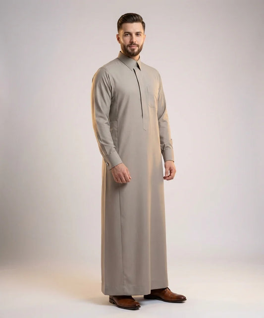 Executive Sand Grey Thobe – Refined Luxury Wear by Haybah featuring an elegant sand grey tone, concealed front placket, structured turn-down collar, premium breathable fabric, executive tailoring, and timeless Gulf sophistication. Designed for business gatherings, Jummah prayers, Eid celebrations, weddings, nikah ceremonies, formal evenings, and distinguished gentlemen seeking refined luxury and comfort. ثوب رمادي رملي فاخر يجمع بين الأناقة الخليجية الراقية والتفصيل الاحترافي للمناسبات الرسمية والاجتماعات ا