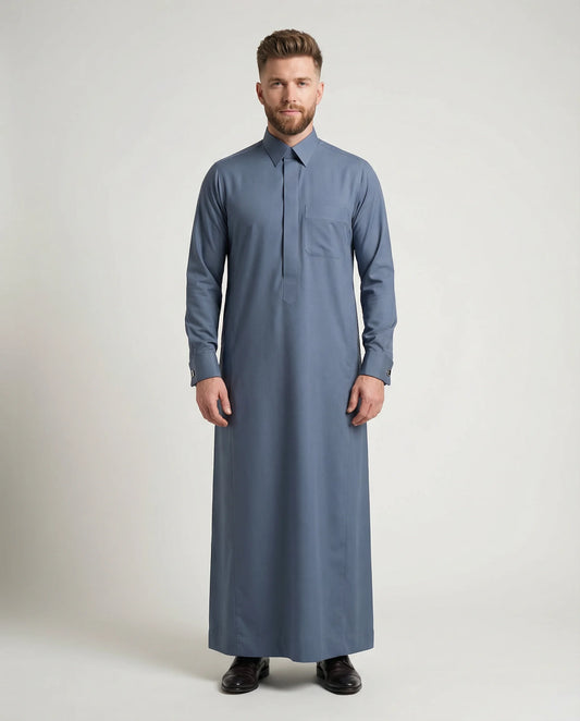 Formal Slate Blue Premium Thobe – Refined Professional Fit by Haybah featuring a sophisticated slate blue tone, concealed front placket, structured turn-down collar, premium breathable fabric, and elegant tailoring designed for business meetings, formal occasions, corporate events, Eid gatherings, and modern professional wear. ثوب أزرق أردوازي فاخر بتصميم رسمي أنيق وقصة متقنة يمنح الرجل مظهراً احترافياً راقياً وحضوراً مميزاً في المناسبات الرسمية واليومية.