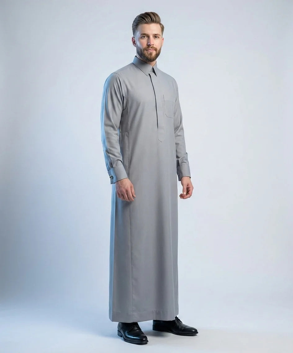 Stone Grey Signature Thobe – Refined Grace Edition by Haybah featuring a sophisticated stone grey tone, structured turn-down collar, concealed front placket, premium breathable fabric, refined tailoring, and elegant executive styling for business meetings, formal gatherings, Jumuah prayers, Eid celebrations, weddings, and distinguished occasions. ثوب رمادي حجري فاخر بتصميم أنيق وقصة متقنة يمنح الرجل حضوراً راقياً ومظهراً احترافياً يناسب المناسبات الرسمية واليومية.