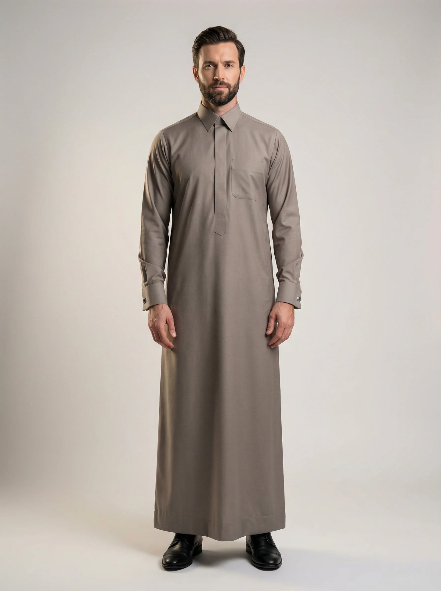 Warm Grey Premium Formal Thobe – Refined Formal Fit by Haybah featuring a sophisticated warm grey tone, concealed front placket, structured turn-down collar, premium breathable fabric, elegant tailored silhouette, and timeless formal styling for business meetings, weddings, Eid gatherings, Jumuah prayers, and distinguished occasions. ثوب رمادي دافئ فاخر بتصميم أنيق وقصة رسمية راقية يمنح الرجل مظهراً احترافياً وحضوراً مميزاً في المناسبات الرسمية واليومية.