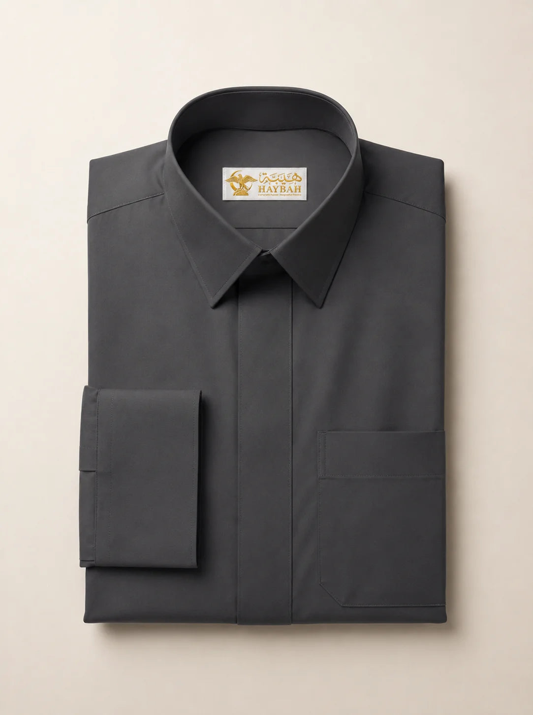 Folded Charcoal Grey Premium Formal Thobe showcasing luxury craftsmanship, rich charcoal grey fabric, concealed placket, structured formal collar, precise stitching, and premium tailoring by Haybah. ثوب رمادي فحمي مطوي بعناية يبرز جودة التصنيع الفاخرة والخياطة الدقيقة والقماش الراقي المصمم للرجل العصري.