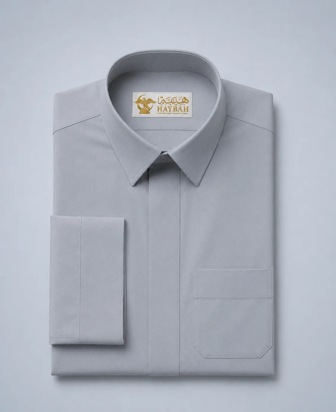 Folded Elite Stone Grey Ceremony Thobe showcasing premium stone grey fabric, concealed placket, luxury craftsmanship, refined stitching, structured collar, and elegant Gulf formalwear design by Haybah. ثوب رمادي حجري فاخر مطوي بعناية يبرز جودة القماش الفاخرة والتفصيل الاحترافي المناسب للمناسبات الرسمية والاحتفالات الراقية.