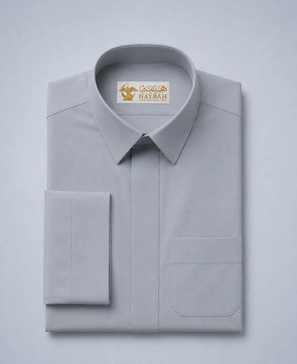 Folded Elite Stone Grey Ceremony Thobe showcasing premium stone grey fabric, concealed placket, luxury craftsmanship, refined stitching, structured collar, and elegant Gulf formalwear design by Haybah. ثوب رمادي حجري فاخر مطوي بعناية يبرز جودة القماش الفاخرة والتفصيل الاحترافي المناسب للمناسبات الرسمية والاحتفالات الراقية.