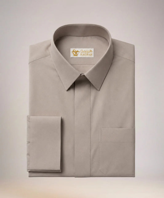 Folded Executive Sand Grey Thobe showcasing premium craftsmanship, elegant sand grey fabric, concealed placket, refined stitching, structured collar, executive styling, and luxury Gulf-inspired tailoring by Haybah. ثوب رمادي رملي فاخر مطوي بعناية يبرز جودة الخياطة والتفاصيل الدقيقة والتصميم الأنيق المناسب للمناسبات الرسمية.