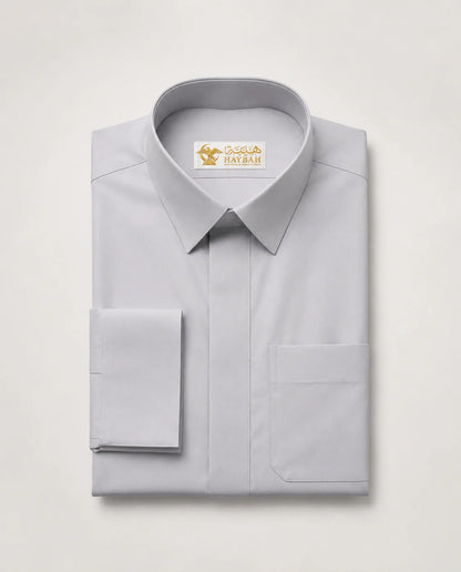 Folded Light Grey Executive Thobe showcasing premium craftsmanship, elegant light grey fabric, concealed placket, structured formal collar, refined finishing details, and sophisticated executive styling by Haybah. ثوب رمادي فاتح مطوي بعناية يبرز جودة التصنيع الفاخرة والتفاصيل الدقيقة والتصميم الرسمي الأنيق للرجل العصري.