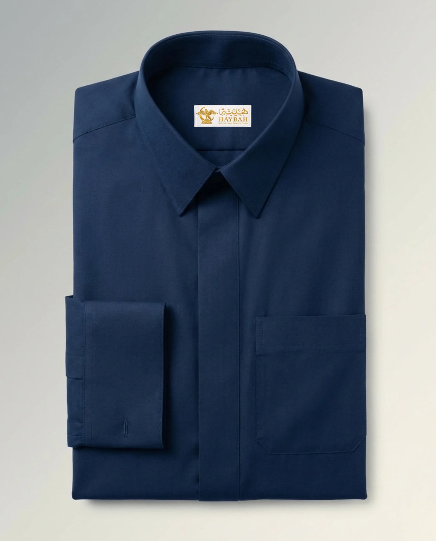 Folded Midnight Blue Premium Formal Thobe showcasing luxury craftsmanship, deep blue premium fabric, concealed placket, structured formal collar, precision stitching, and elegant tailoring by Haybah. ثوب أزرق ليلي مطوي بعناية يبرز جودة التصنيع الفاخرة والخياطة الدقيقة والقماش الراقي المصمم للرجل العصري الأنيق.
