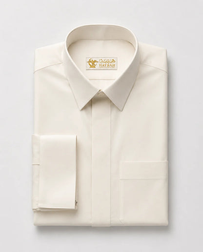 Folded Off-White Royal Executive Thobe showcasing premium craftsmanship, structured formal collar, concealed front placket, luxury off-white fabric, and sophisticated formal wear detailing by Haybah. ثوب أوف وايت مطوي بعناية يبرز جودة التصنيع الفاخرة والتفاصيل الدقيقة والتصميم الرسمي الراقي المناسب للمناسبات الراقية.
