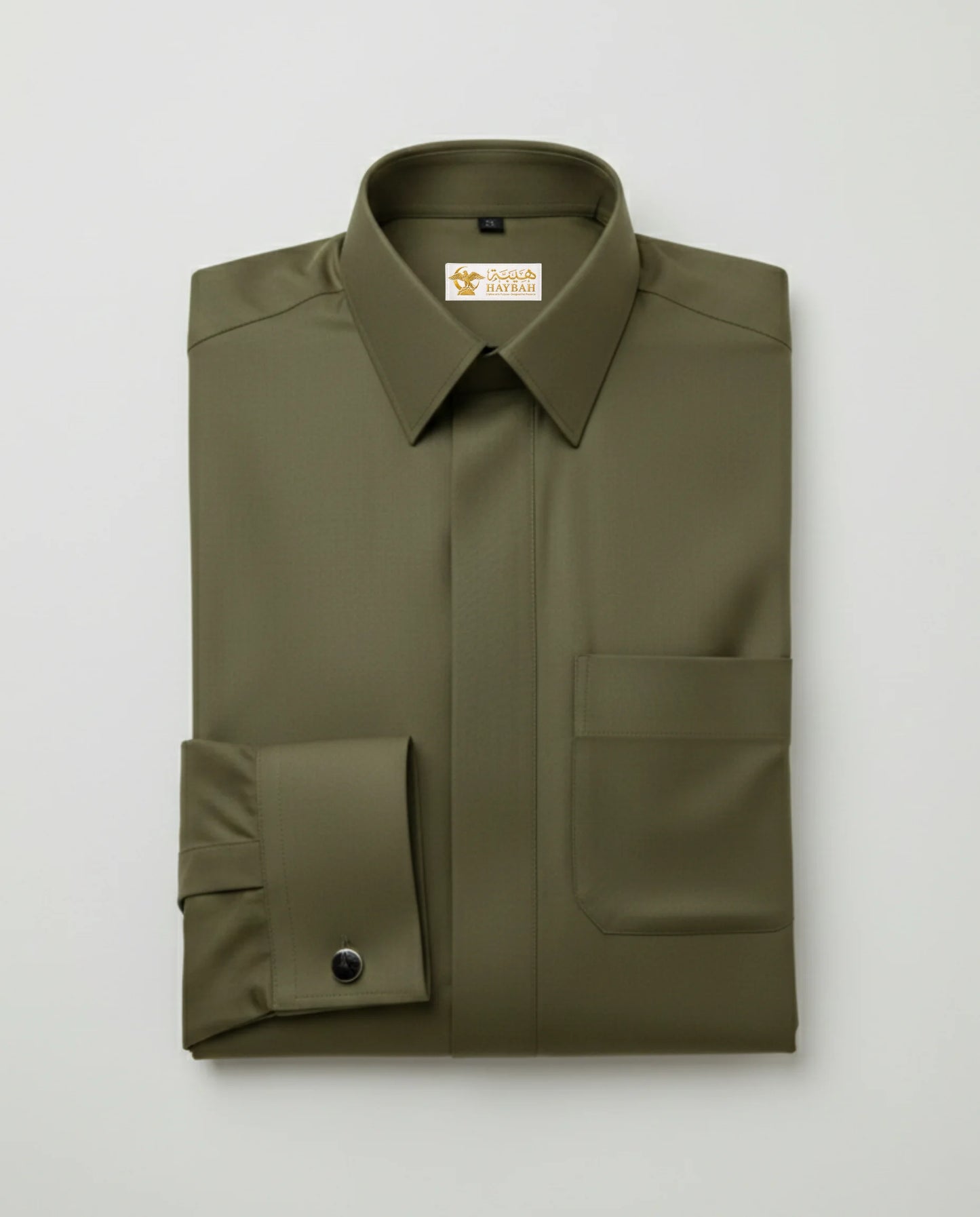 Folded Olive Green Executive Thobe showcasing premium craftsmanship, luxury olive green fabric, concealed placket, structured collar, refined stitching, elegant finishing, and sophisticated Gulf formalwear tailoring by Haybah. ثوب زيتوني فاخر مطوي بعناية يبرز جودة القماش والخياطة الدقيقة والتصميم الأنيق المناسب للمناسبات الرسمية والاحتفالات الراقية.