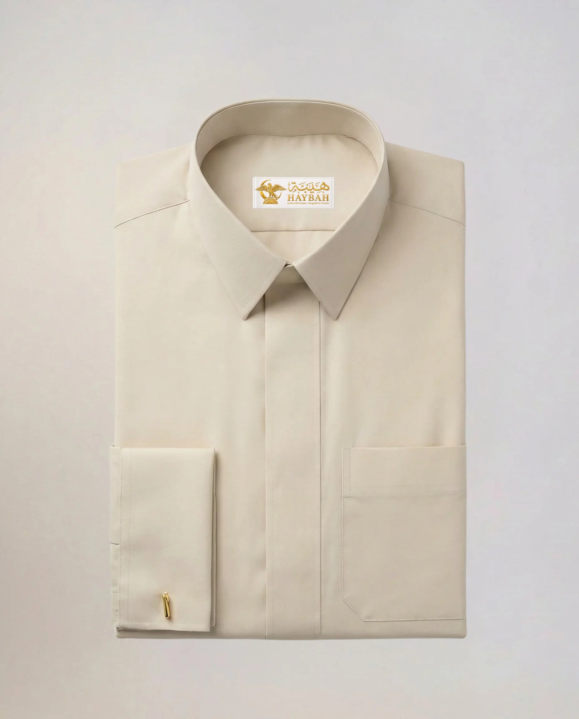 Folded Pearl Beige Modern Formal Thobe showcasing premium craftsmanship, elegant pearl beige fabric, concealed placket, structured collar, refined stitching, and luxury formal wear detailing by Haybah. ثوب بيج لؤلؤي مطوي بعناية يبرز جودة الخياطة والتصنيع الفاخر والتفاصيل الأنيقة المناسبة للرجل العصري الباحث عن التميز.