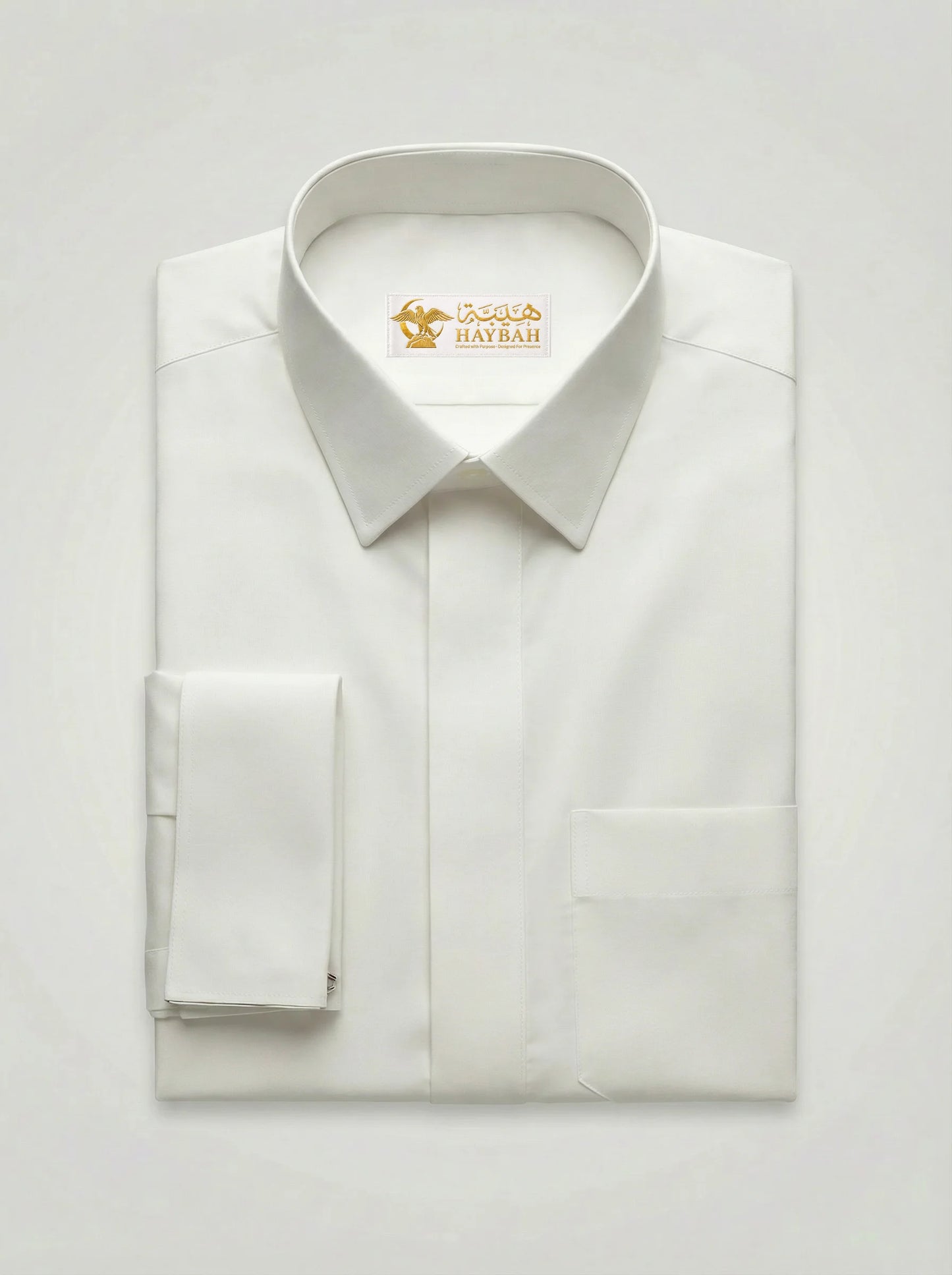 Folded Pearl White Luxury Thobe showcasing premium craftsmanship, elegant pearl white fabric, concealed placket, refined stitching, structured collar, executive design, and luxury Gulf-inspired tailoring by Haybah. ثوب أبيض لؤلؤي فاخر مطوي بعناية يبرز جودة الخياطة والتفاصيل الراقية والتصميم الأنيق المناسب للمناسبات الرسمية.