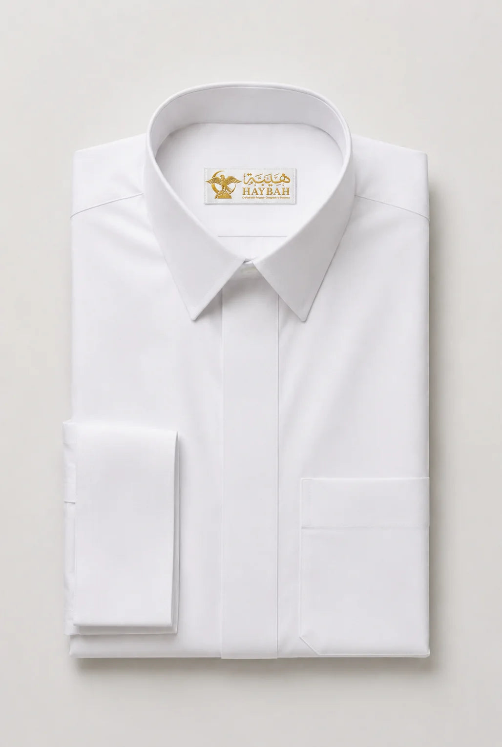 Folded Pure White Prestige Thobe showcasing premium craftsmanship, luxury white fabric, concealed placket, structured collar, elegant stitching, and sophisticated Gulf-inspired tailoring by Haybah. ثوب أبيض فاخر مطوي بعناية يبرز جودة القماش والخياطة الدقيقة والتصميم الأنيق المناسب للمناسبات الرسمية والاحتفالات الراقية.