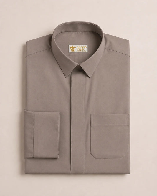 Folded Warm Grey Everyday Thobe displaying premium craftsmanship, structured collar, hidden placket, precise stitching, and breathable luxury fabric. Premium Saudi thobe, luxury jubba, men's Islamic clothing, ثوب سعودي فاخر, ثوب رجالي كلاسيكي, جلابية رجالية فاخرة, دشداشة رجالية أنيقة, ثوب يومي راقي, elegant Arab menswear suitable for Eid, Umrah travel, mosque visits, formal occasions, and modern professional lifestyles.