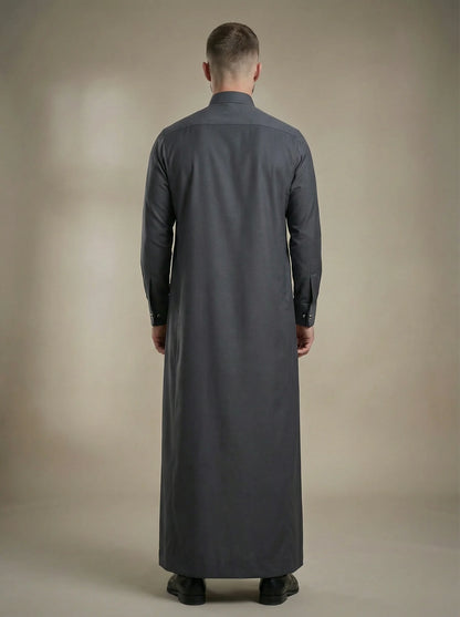 Back view of Charcoal Grey Premium Formal Thobe highlighting a clean tailored silhouette, elegant drape, premium fabric construction, and sophisticated formal menswear craftsmanship for modern gentlemen. منظر خلفي لثوب رمادي فحمي فاخر يظهر القصة المتوازنة والانسيابية الراقية والخياطة الاحترافية لمظهر أنيق ومتميز.