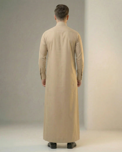 Back view of Desert Beige Premium Formal Thobe highlighting its clean tailored silhouette, premium fabric drape, elegant structure, and refined professional styling suitable for modern gentlemen and formal occasions. منظر خلفي لثوب بيج صحراوي فاخر يظهر القصة المتناسقة والانسيابية الراقية والخياطة الاحترافية لمظهر أنيق ومتميز.