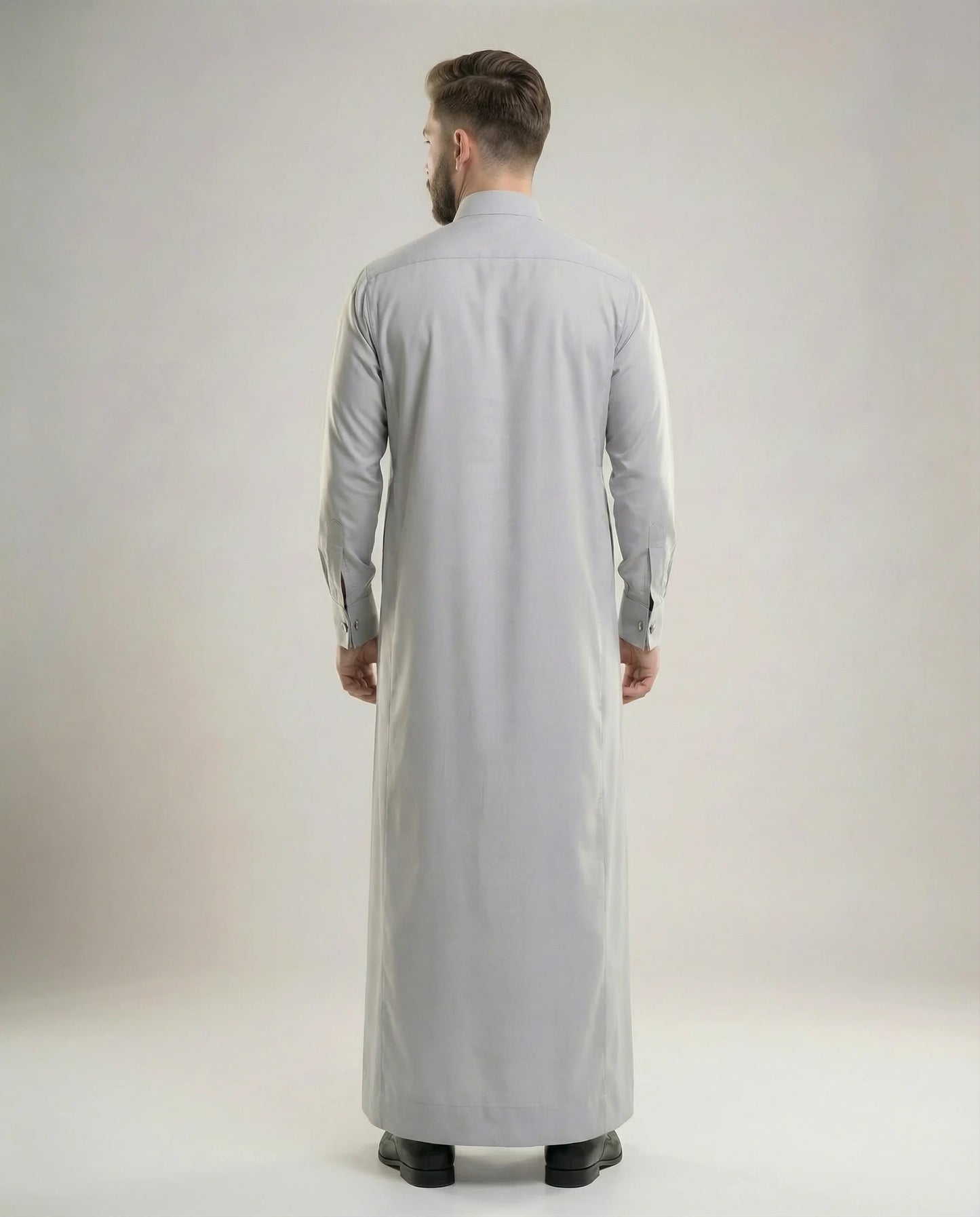 Back view of Light Grey Luxury Thobe highlighting clean tailoring, premium construction, graceful drape, modern silhouette, and timeless Gulf luxury styling suitable for executive events, weddings, formal occasions, Eid celebrations, and distinguished gatherings. منظر خلفي لثوب رمادي فاتح فاخر يبرز الانسيابية الراقية والتفصيل الاحترافي والمظهر الأنيق للمناسبات الرسمية.