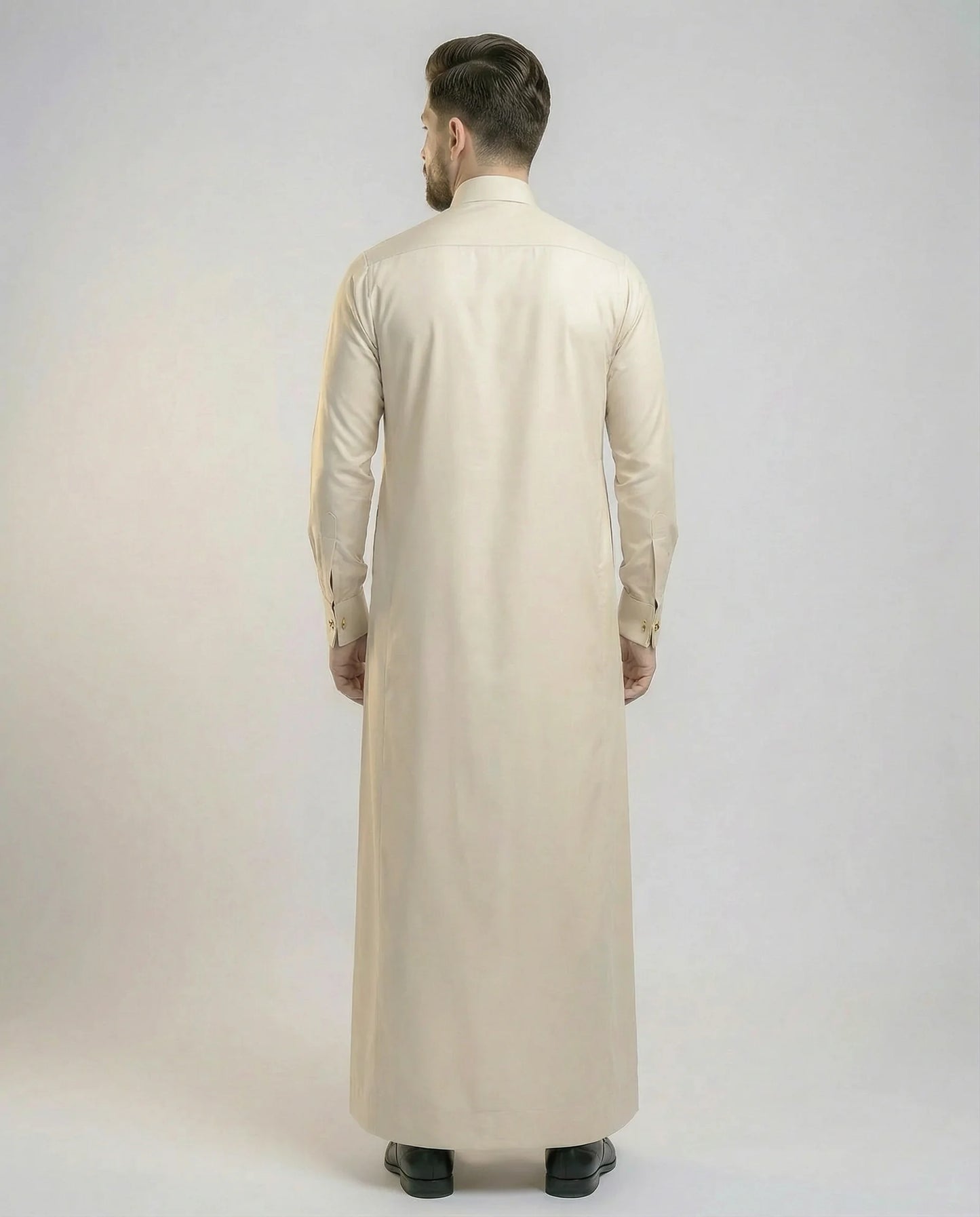 Back view of Pearl Beige Modern Formal Thobe highlighting its clean silhouette, premium fabric drape, tailored construction, and refined elegance suitable for professional and formal settings. منظر خلفي لثوب بيج لؤلؤي فاخر يظهر القصة الانسيابية والتفصيل الاحترافي والمظهر الراقي المناسب للمناسبات الرسمية.