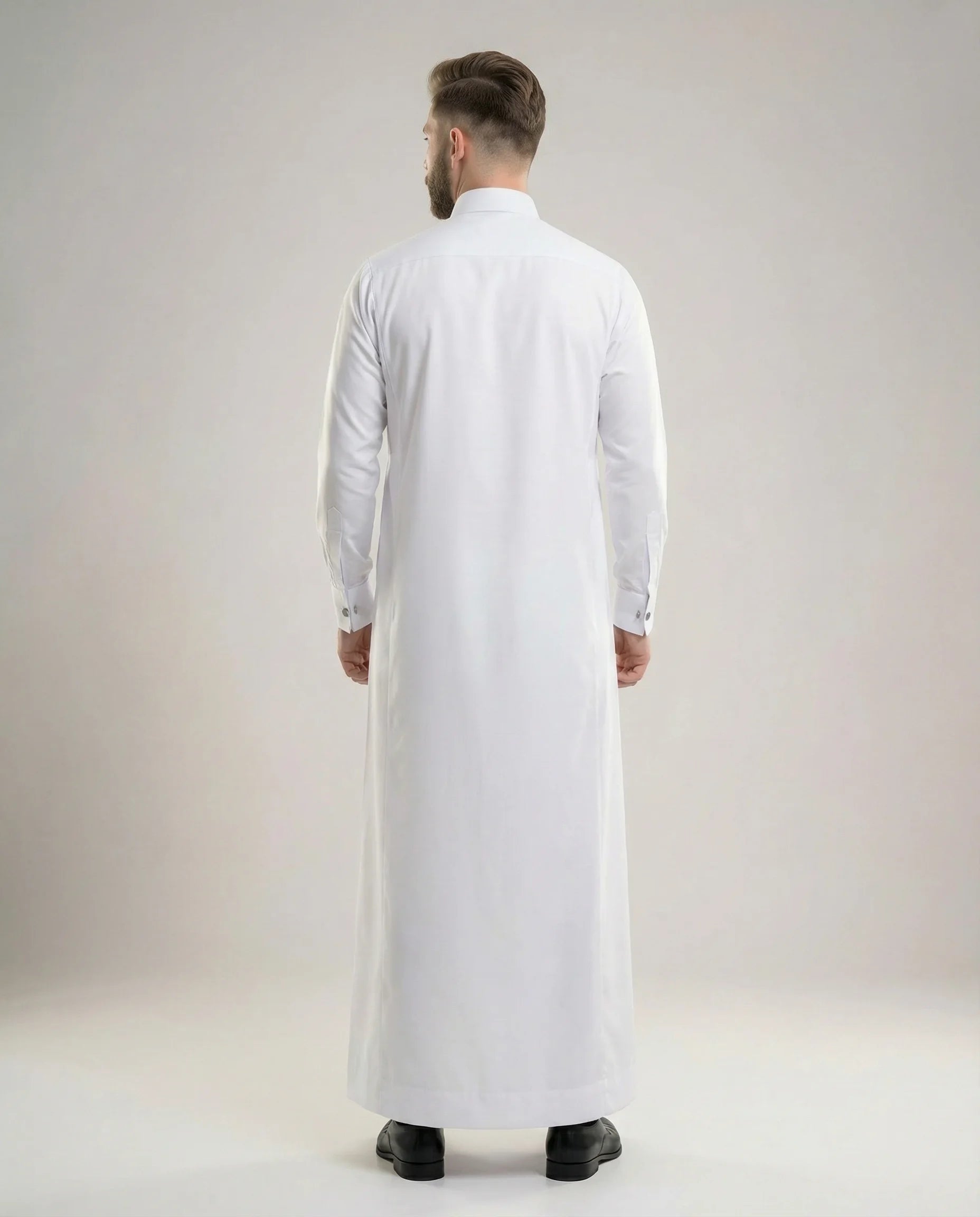 Back view of Pure White Prestige Thobe highlighting clean tailoring, elegant drape, refined silhouette, premium construction, and timeless Gulf formal wear styling for weddings, Eid gatherings, nikah ceremonies, and executive occasions. منظر خلفي لثوب أبيض فاخر يظهر الانسيابية الراقية والتفصيل الاحترافي والمظهر الأنيق المناسب للمناسبات المميزة.