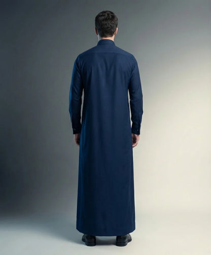 Back view of Royal Midnight Formal Thobe highlighting clean tailoring, flowing silhouette, premium construction, elegant drape, and timeless Gulf luxury styling for executive occasions, weddings, formal events, and distinguished celebrations. منظر خلفي لثوب أزرق ليلي فاخر يبرز الانسيابية الأنيقة والتفصيل الراقي للمناسبات الرسمية والخليجية الراقية.
