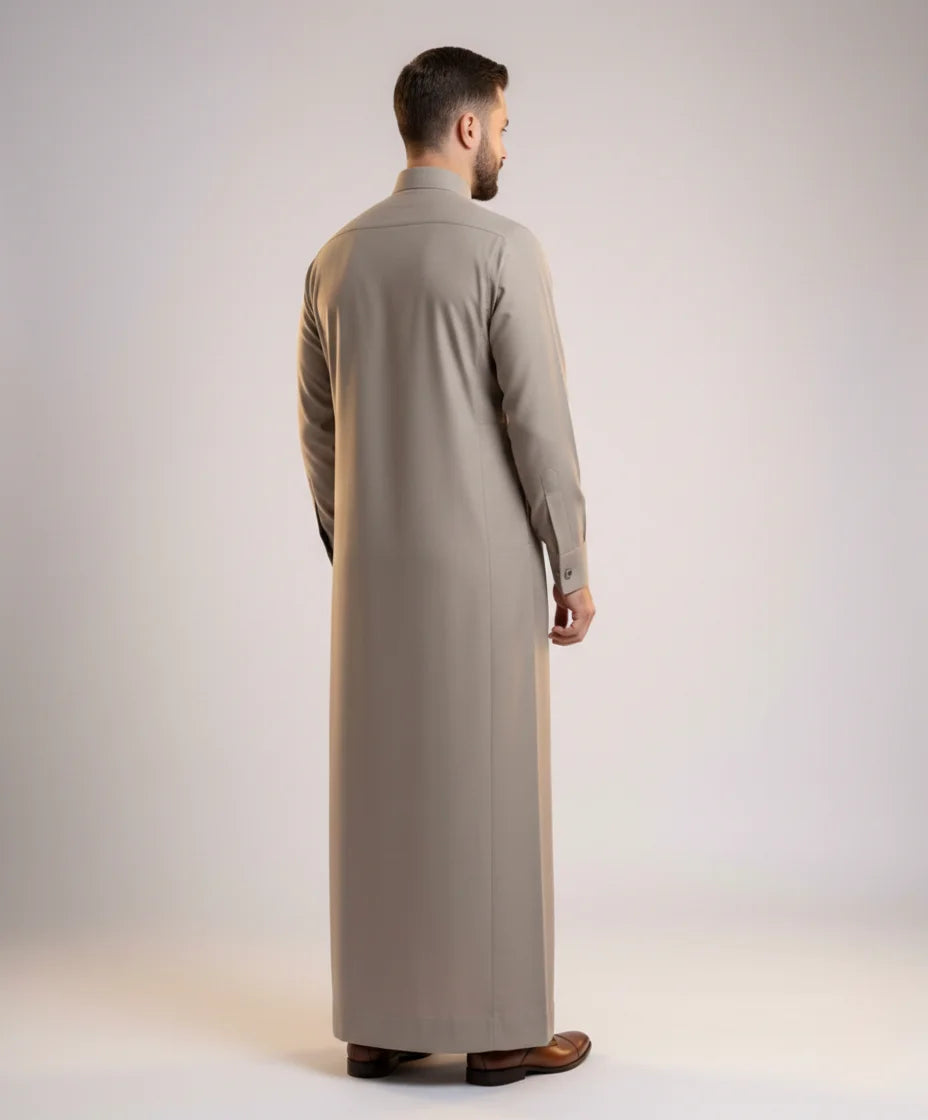 Back view of Sand Grey Executive Thobe highlighting a clean tailored silhouette, premium fabric drape, balanced proportions, and refined formal menswear craftsmanship suitable for professional and ceremonial occasions. منظر خلفي لثوب رمادي رملي فاخر يظهر القصة المتقنة والانسيابية المثالية والتفصيل الاحترافي لمظهر أنيق ومتوازن.