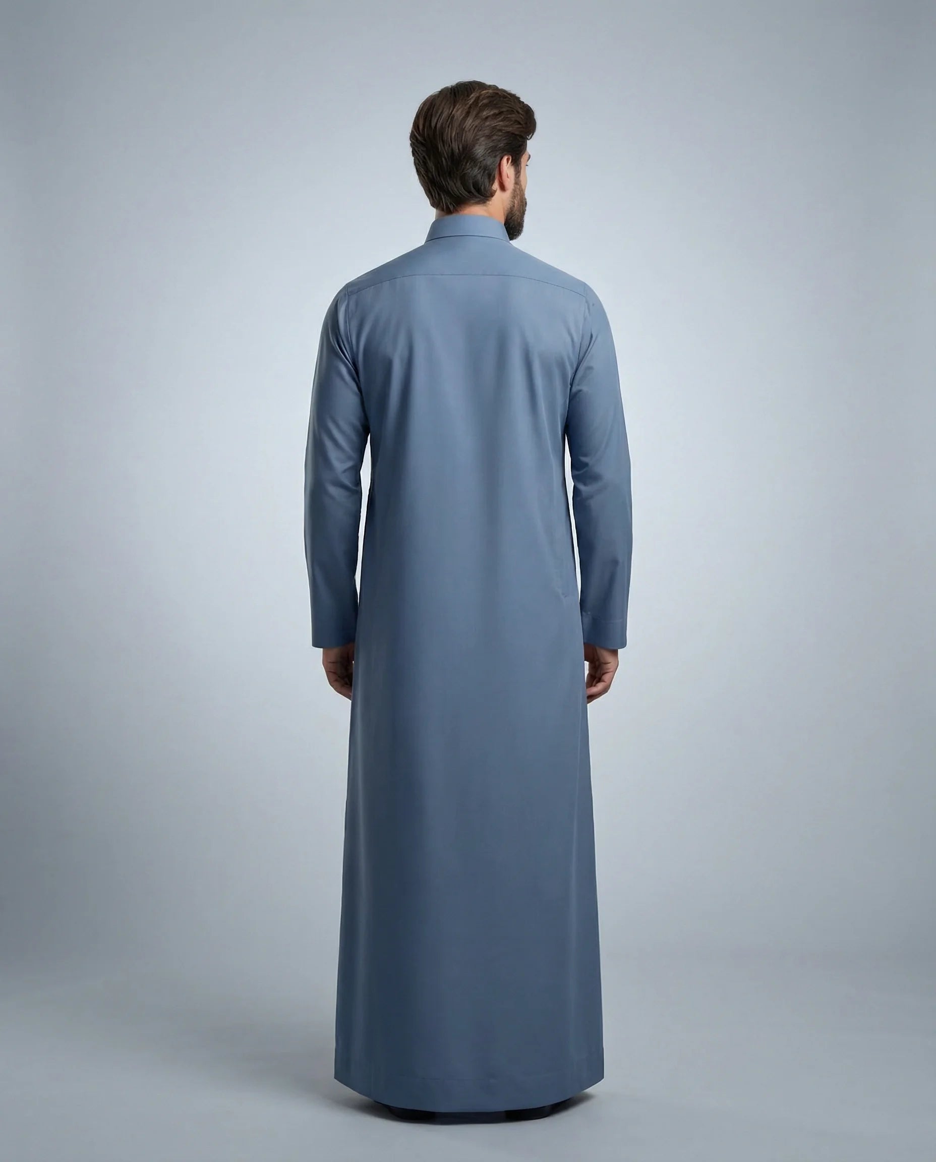 Back view of Steel Blue Classic Thobe highlighting clean tailoring, premium fabric drape, modest full-length silhouette, and elegant contemporary construction. Men's Saudi thobe, luxury Arabic clothing, premium jubba, ثوب رجالي سعودي, ثوب أزرق فولاذي, ثوب رسمي رجالي, جلابية رجالية طويلة, ملابس إسلامية رجالية فاخرة, modern modest fashion combining comfort, sophistication, and timeless Middle Eastern elegance.