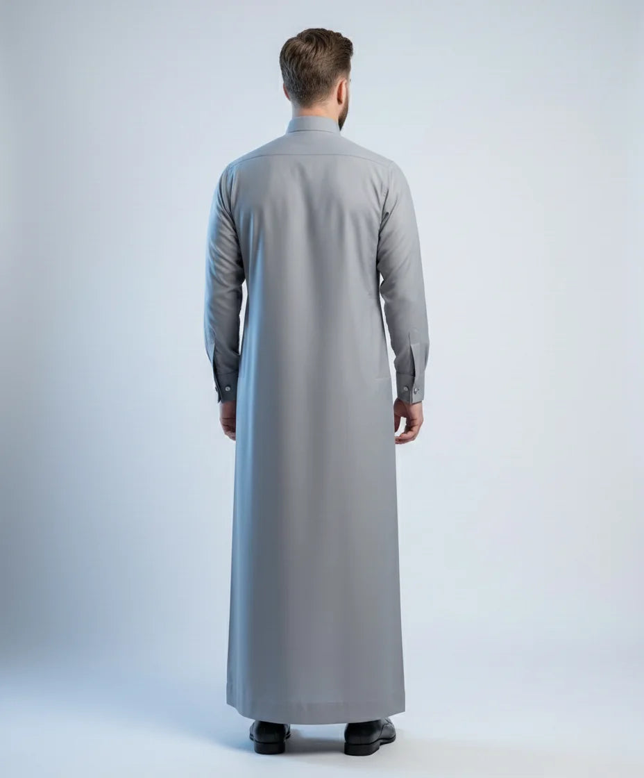 Back view of Stone Grey Signature Thobe highlighting a clean tailored silhouette, balanced proportions, premium fabric drape, and sophisticated formal menswear craftsmanship for modern gentlemen. منظر خلفي لثوب رمادي حجري فاخر يظهر القصة المتوازنة والانسيابية الراقية والخياطة الاحترافية لمظهر أنيق ومتميز.