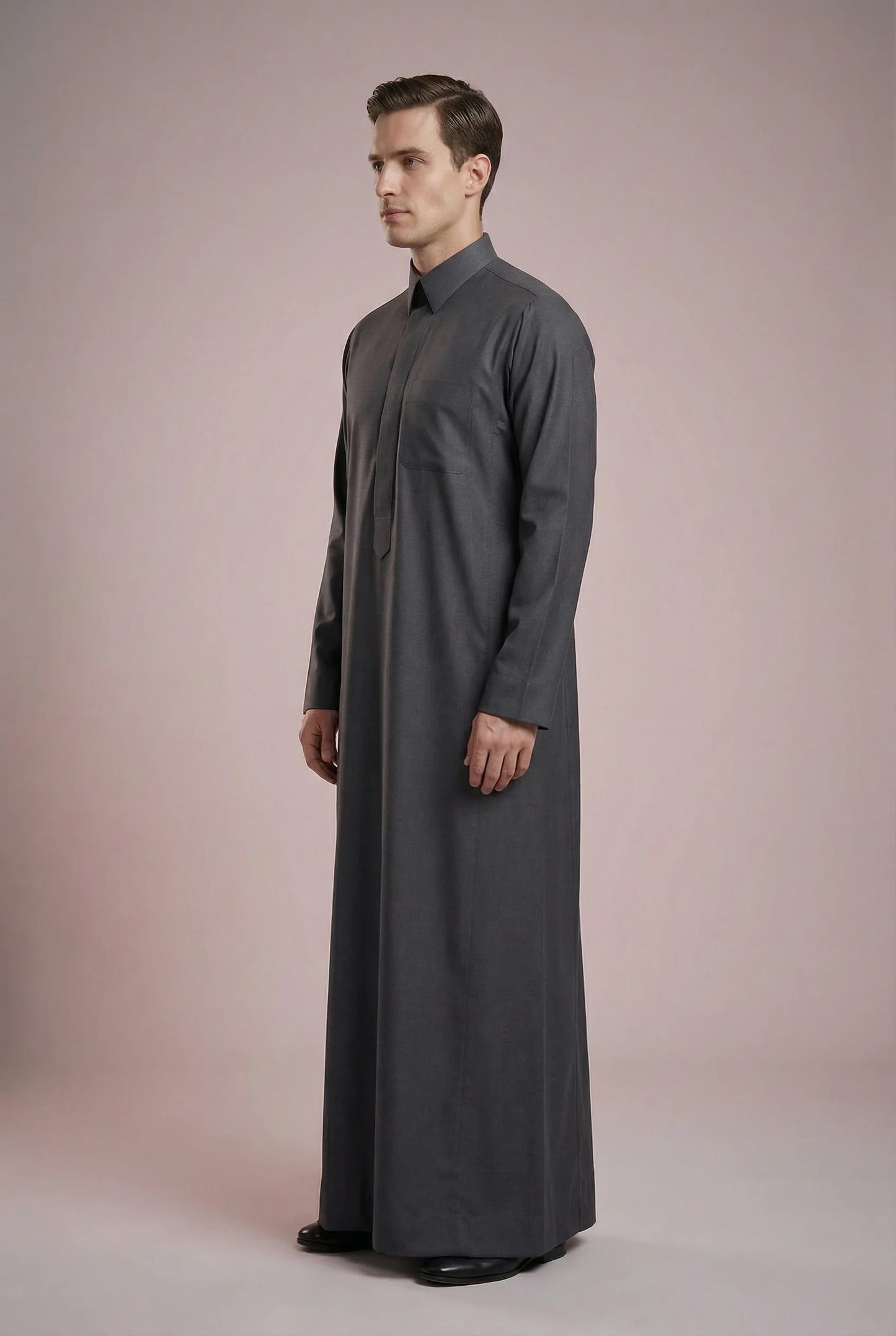 Side profile of Charcoal Grey Executive Saudi Thobe displaying a streamlined silhouette, tailored construction, structured turn-down collar, and premium charcoal fabric. Luxury men's jubba, Saudi thobe for men, traditional Islamic clothing, ثوب سعودي أنيق, ثوب رجالي فاخر, دشداشة رجالية رسمية, جلابية رجالية مودرن, elegant modest wear crafted for business meetings, special events, and everyday sophistication.