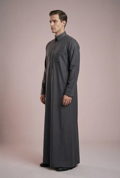 Side profile of Charcoal Grey Executive Saudi Thobe displaying a streamlined silhouette, tailored construction, structured turn-down collar, and premium charcoal fabric. Luxury men's jubba, Saudi thobe for men, traditional Islamic clothing, ثوب سعودي أنيق, ثوب رجالي فاخر, دشداشة رجالية رسمية, جلابية رجالية مودرن, elegant modest wear crafted for business meetings, special events, and everyday sophistication.