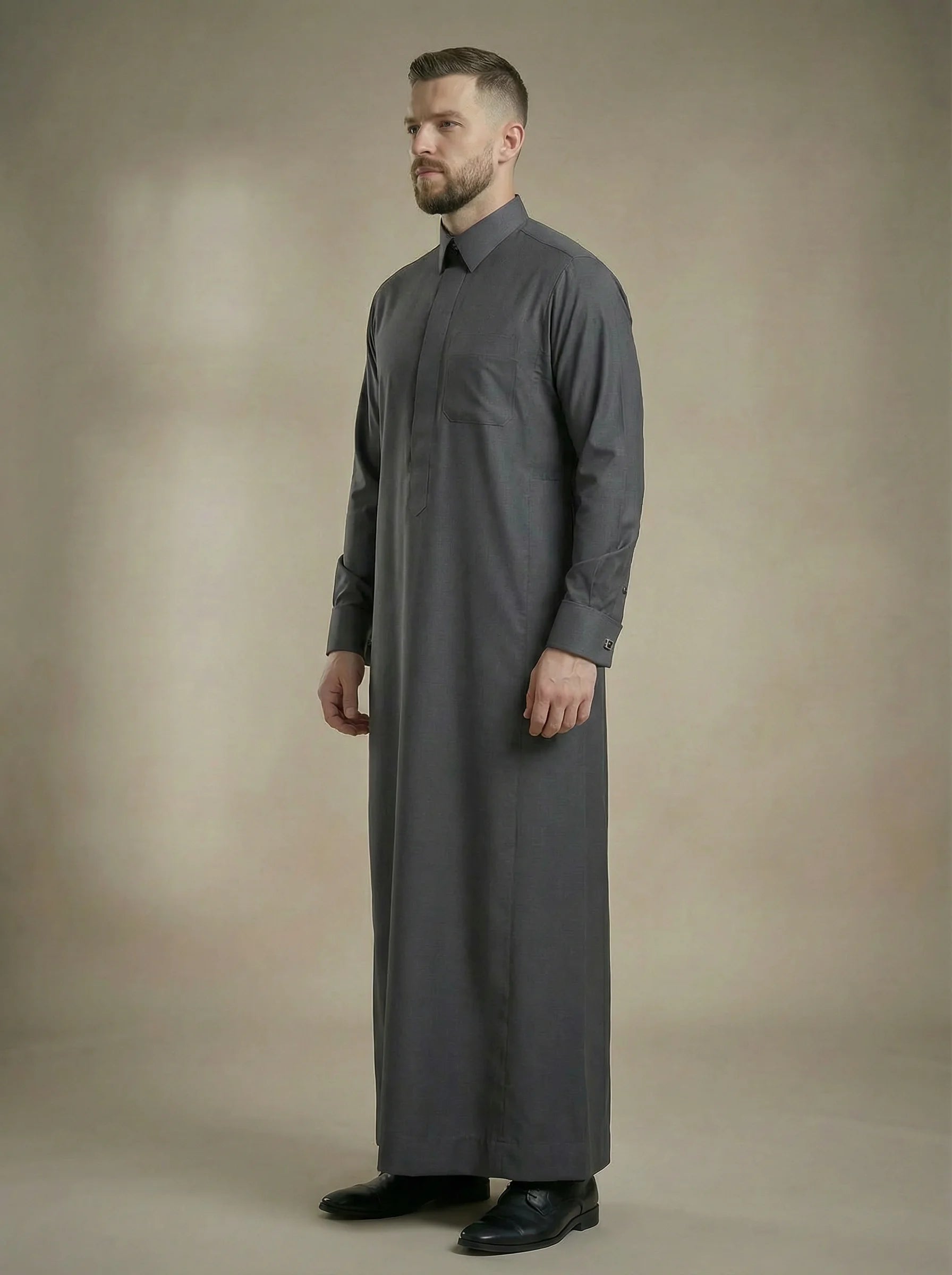 Side profile of Charcoal Grey Signature Thobe featuring luxury tailoring, premium comfort, concealed placket, executive silhouette, and modern Gulf elegance. Ideal for weddings, formal gatherings, business events, nikah ceremonies, and prestigious occasions. إطلالة جانبية لثوب رمادي فحمي فاخر يجسد الأناقة الخليجية الراقية والتفصيل الفاخر للمناسبات المميزة.