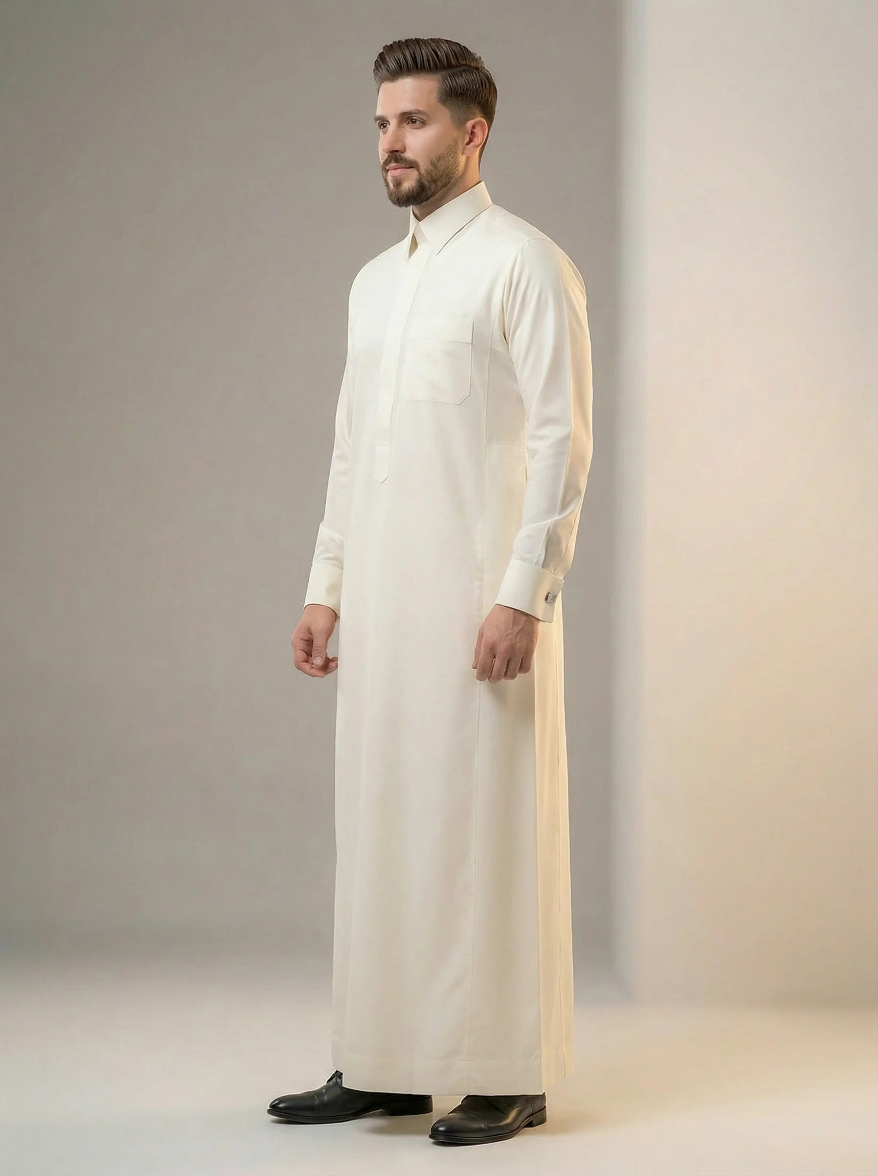 Side profile view of Cream White Premium Formal Thobe featuring executive tailoring, structured fit, breathable luxury fabric, concealed placket, and timeless formal elegance. منظر جانبي لثوب كريمي فاخر يبرز التصميم العصري والخياطة الدقيقة والأناقة الراقية المناسبة للمناسبات الرسمية.