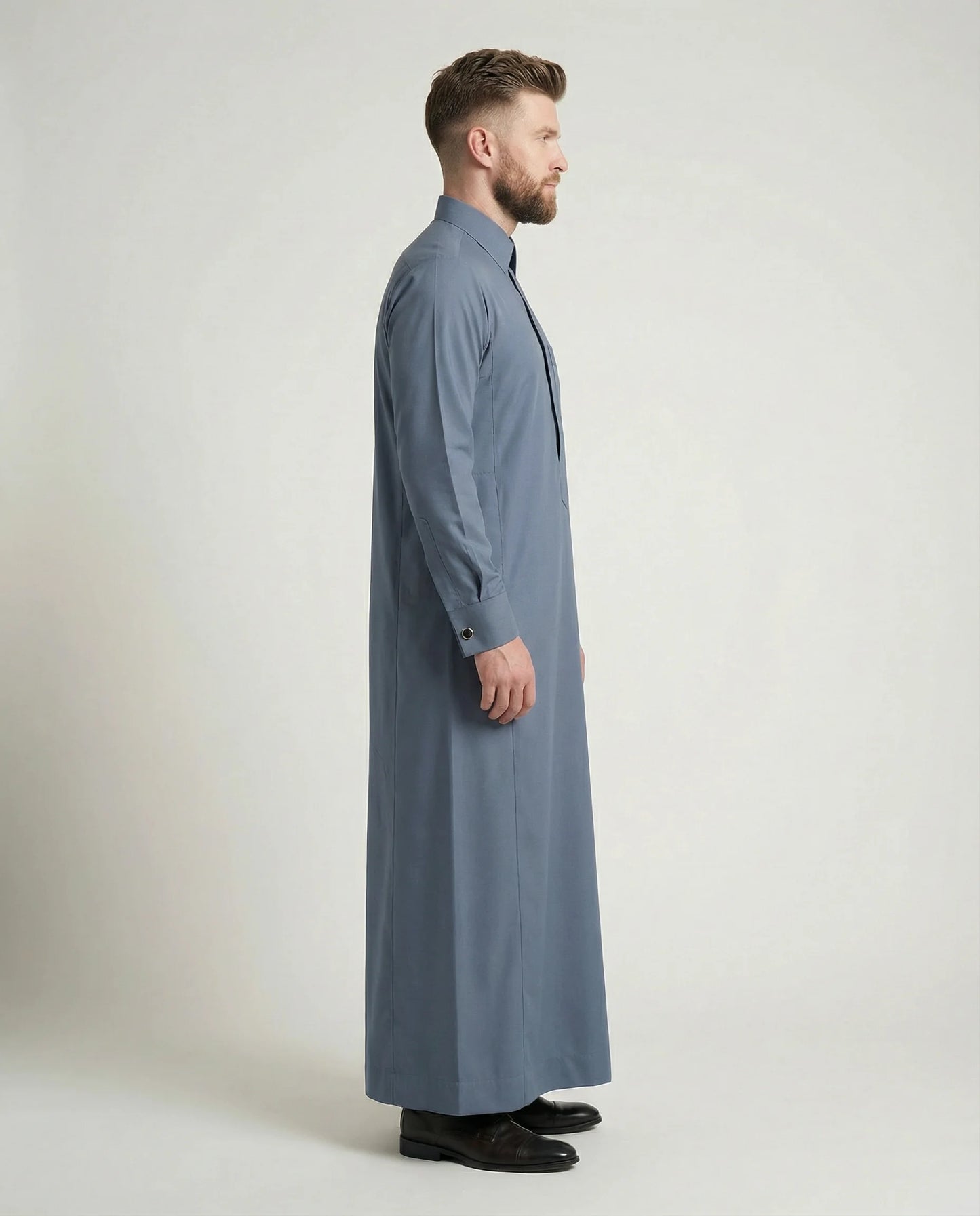 Walking view of Formal Slate Blue Premium Thobe featuring confident style, breathable comfort, executive tailoring, concealed placket, and timeless sophistication suitable for office wear, formal events, and distinguished occasions. إطلالة أثناء المشي لثوب أزرق أردوازي فاخر تبرز الأناقة العصرية والراحة العالية والخياطة المتقنة للرجل الواثق والأنيق.