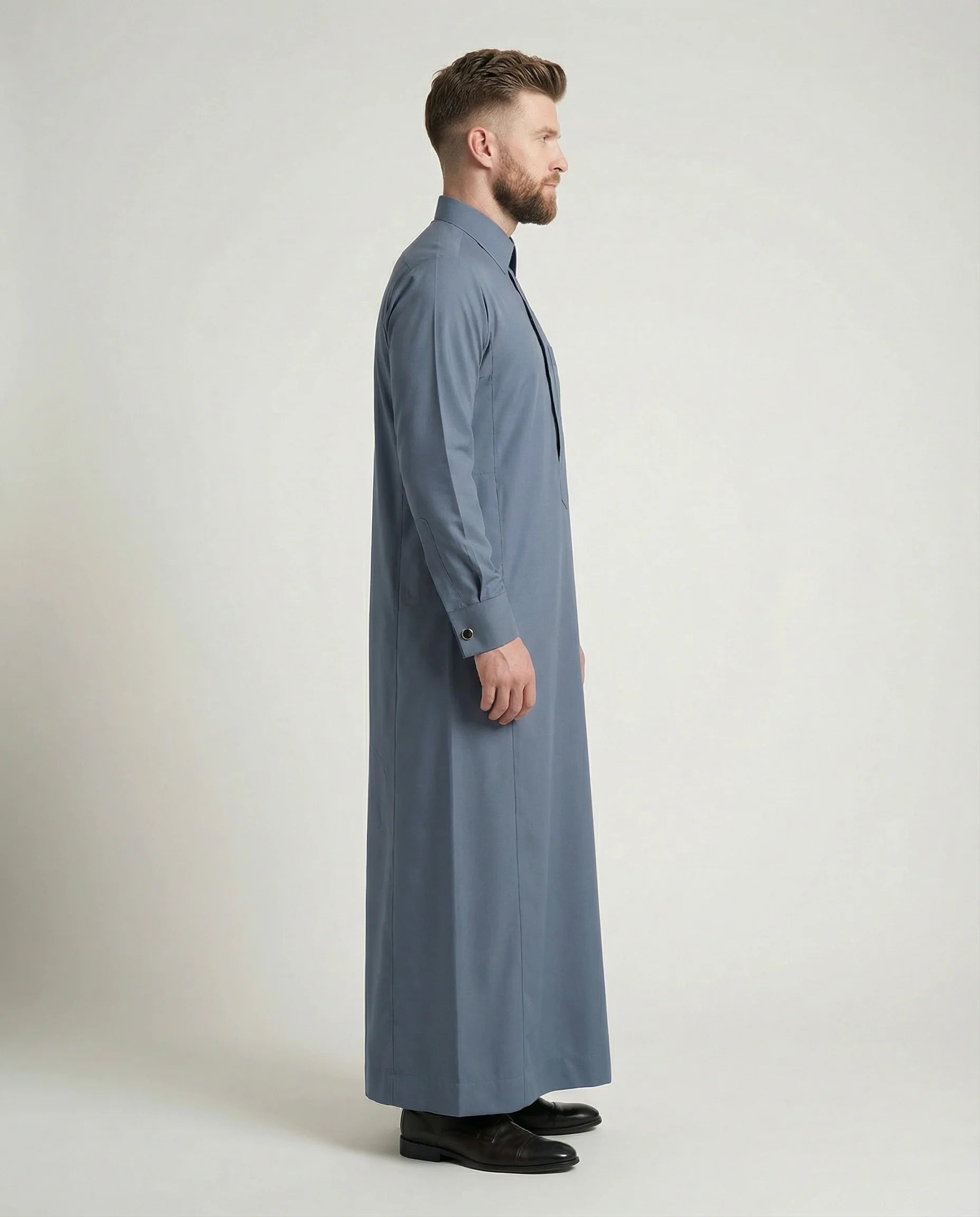 Walking view of Formal Slate Blue Premium Thobe featuring confident style, breathable comfort, executive tailoring, concealed placket, and timeless sophistication suitable for office wear, formal events, and distinguished occasions. إطلالة أثناء المشي لثوب أزرق أردوازي فاخر تبرز الأناقة العصرية والراحة العالية والخياطة المتقنة للرجل الواثق والأنيق.
