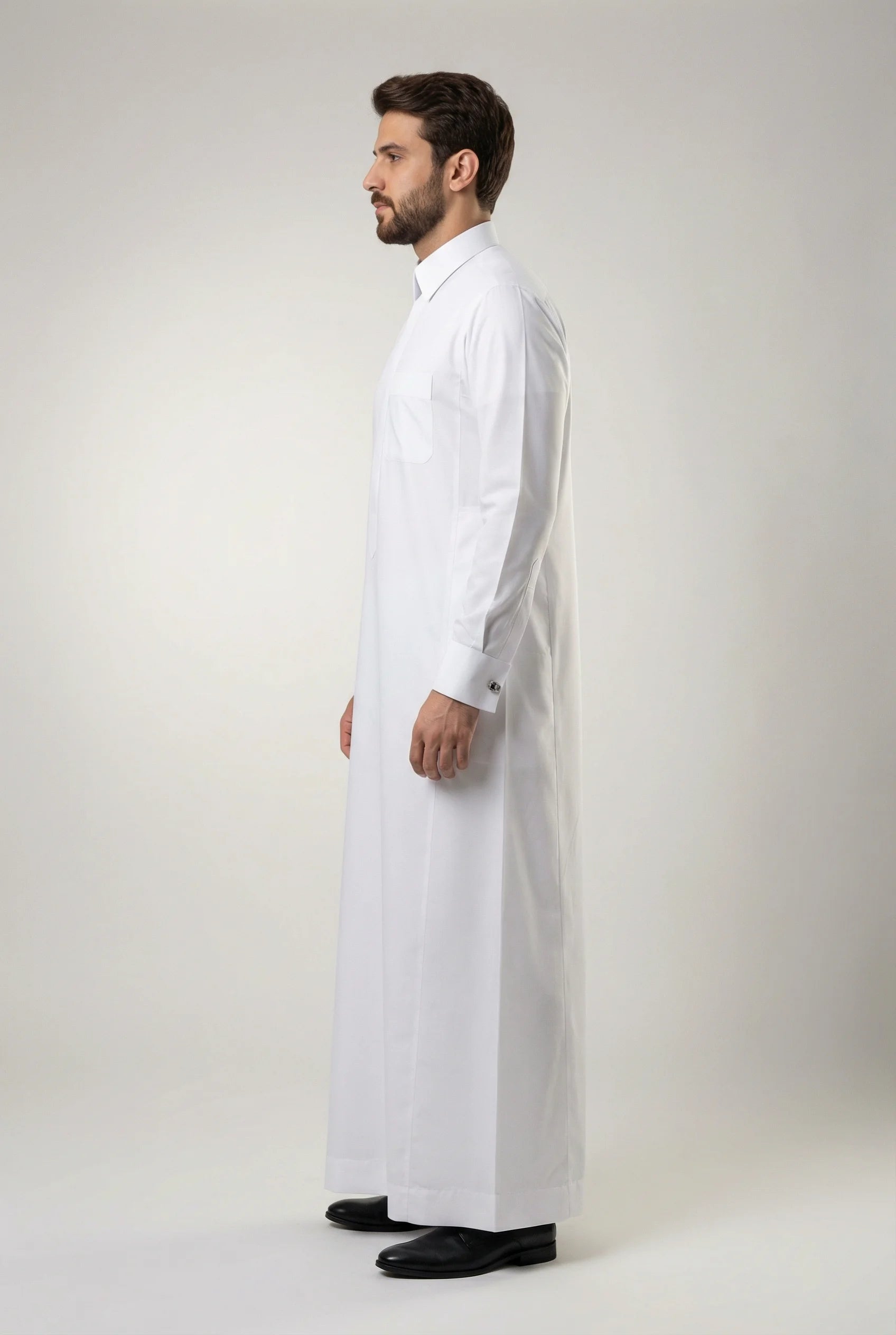 Side profile of Imperial White Thobe featuring a streamlined silhouette, concealed placket, premium comfort, structured collar, luxury tailoring, and elegant Gulf fashion crafted for weddings, formal events, Eid celebrations, and sophisticated menswear collections. منظر جانبي لثوب أبيض فاخر يبرز القصة الأنيقة والفخامة الخليجية والتفاصيل الدقيقة.