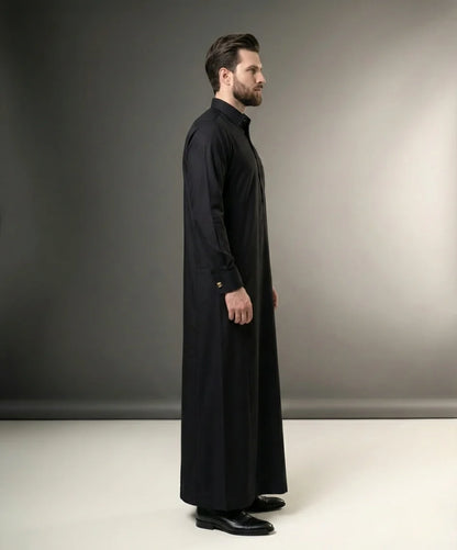 Side profile of Jet Black Executive Thobe featuring a streamlined silhouette, structured collar, concealed placket, executive tailoring, premium comfort, and modern Gulf fashion sophistication with a distinguished formal appearance. منظر جانبي لثوب أسود فاحم فاخر يبرز الانسيابية الأنيقة والتفصيل الاحترافي والمظهر التنفيذي الراقي للرجل العصري.