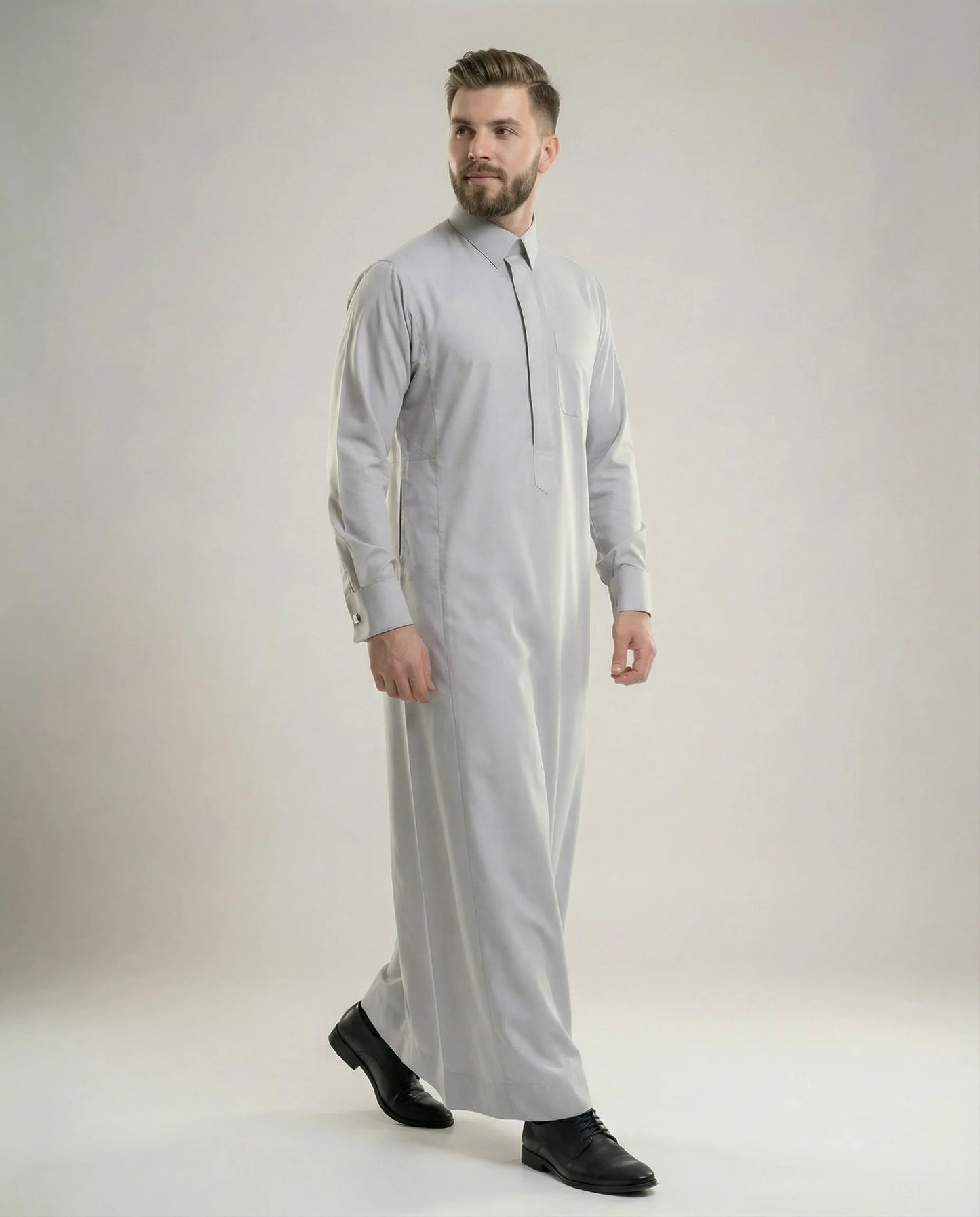 Walking view of Light Grey Executive Thobe featuring timeless elegance, premium breathable fabric, concealed placket, structured collar, and modern executive styling for confident professional wear. إطلالة أثناء المشي لثوب رمادي فاتح فاخر تبرز الأناقة العصرية والخياطة المتقنة والراحة المثالية للرجل الأنيق.
