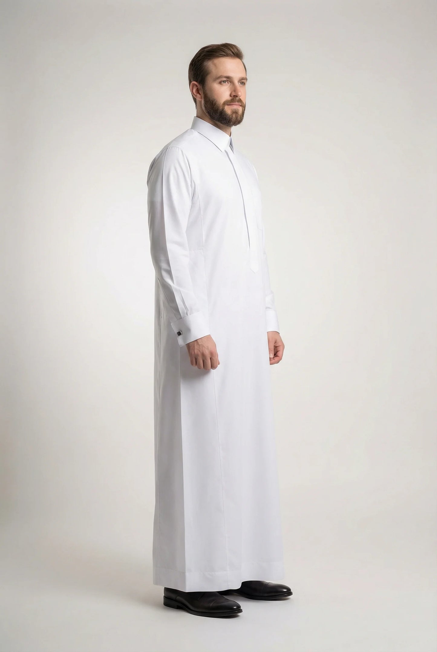 Side profile of Pure White Prestige Thobe featuring a streamlined silhouette, concealed placket, structured collar, luxury tailoring, premium comfort, and sophisticated Gulf fashion designed for formal events, weddings, Eid celebrations, and executive wear. منظر جانبي لثوب أبيض فاخر يبرز القصة الأنيقة والفخامة الخليجية والتفاصيل الدقيقة.
