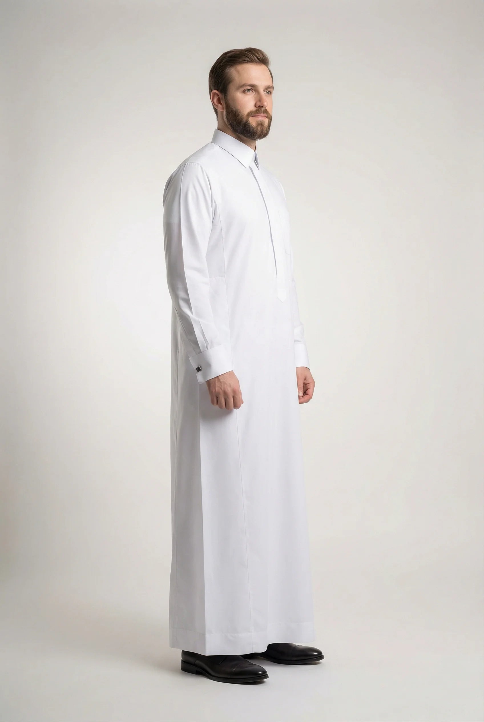 Side profile of Pure White Prestige Thobe featuring a streamlined silhouette, concealed placket, structured collar, luxury tailoring, premium comfort, and sophisticated Gulf fashion designed for formal events, weddings, Eid celebrations, and executive wear. منظر جانبي لثوب أبيض فاخر يبرز القصة الأنيقة والفخامة الخليجية والتفاصيل الدقيقة.