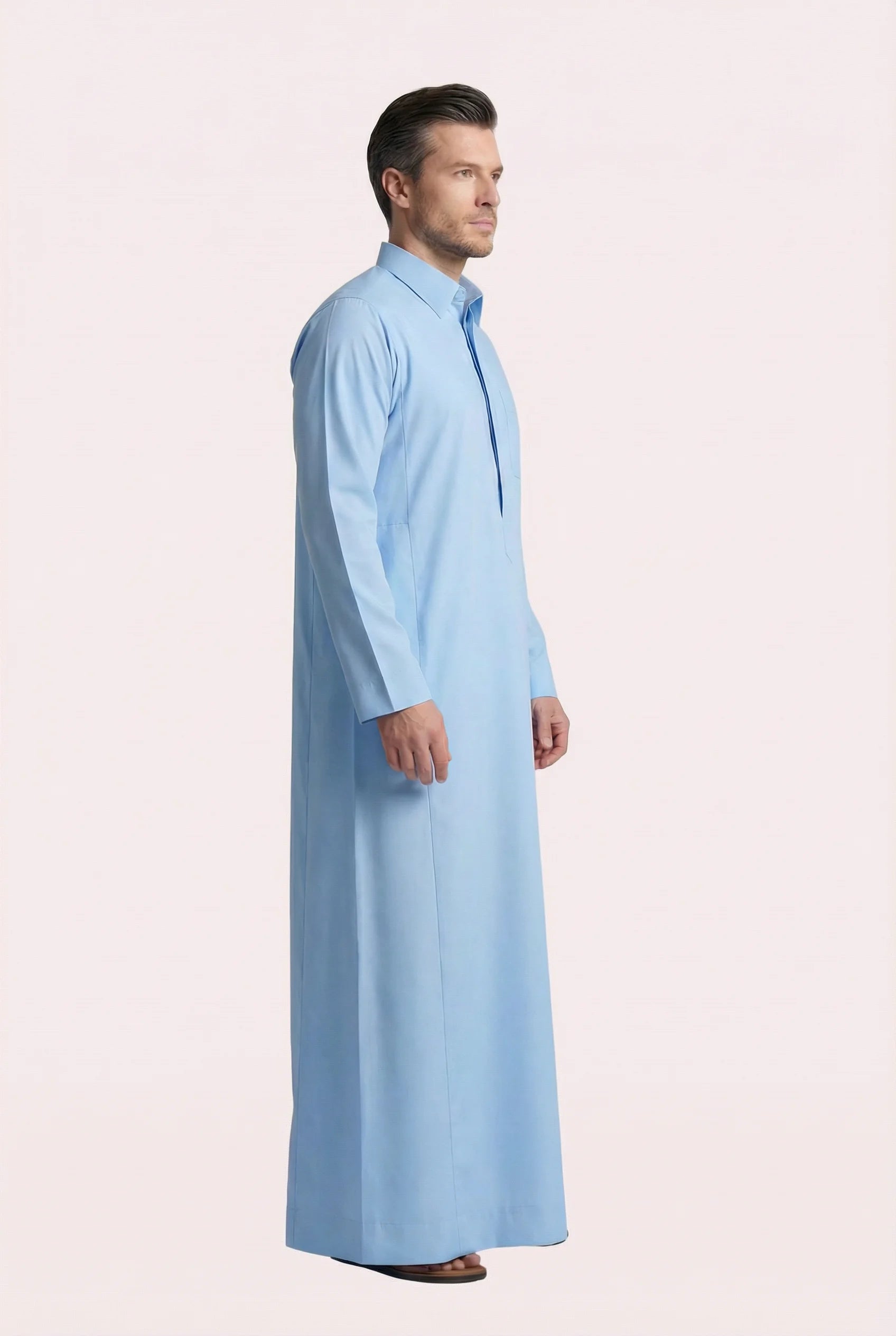 Side profile of Sky Blue Classic Everyday Thobe highlighting modern tailoring, streamlined silhouette, structured collar, and lightweight breathable fabric. Luxury men's thobe, Saudi jubba, Arabic clothing, ثوب سعودي أنيق, ثوب رجالي فاخر, ثوب أزرق فاتح, دشداشة رجالية رسمية, جلابية رجالية مودرن, premium Islamic menswear crafted for professional environments, Ramadan evenings, Eid celebrations, and elevated daily wear.