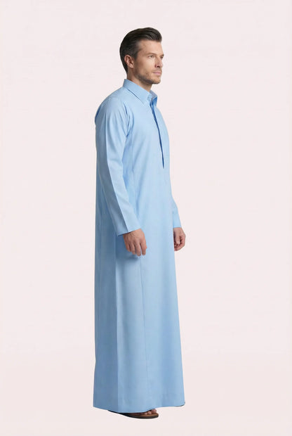 Side profile of Sky Blue Classic Everyday Thobe highlighting modern tailoring, streamlined silhouette, structured collar, and lightweight breathable fabric. Luxury men's thobe, Saudi jubba, Arabic clothing, ثوب سعودي أنيق, ثوب رجالي فاخر, ثوب أزرق فاتح, دشداشة رجالية رسمية, جلابية رجالية مودرن, premium Islamic menswear crafted for professional environments, Ramadan evenings, Eid celebrations, and elevated daily wear.