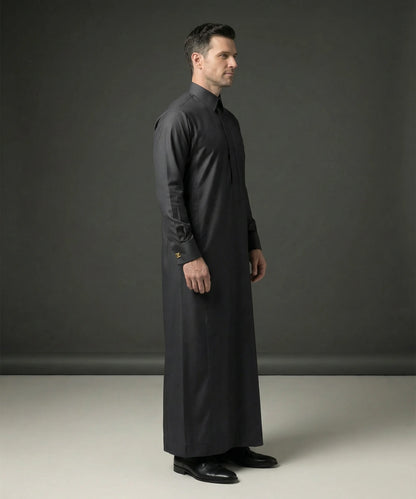 Side profile of Smoke Black Premium Thobe featuring a streamlined silhouette, structured collar, concealed placket, executive tailoring, premium comfort, and contemporary Gulf fashion elegance with a distinguished formal look. منظر جانبي لثوب أسود دخاني فاخر يبرز الانسيابية المثالية والتفصيل الدقيق والأناقة العصرية للرجل الأنيق.