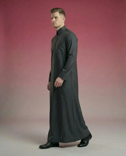 Smoke Black Classic Thobe in walking side profile showcasing elegant movement, breathable premium fabric, concealed placket, and refined Saudi design. Luxury men's thobe, Saudi jubba, Arabic menswear, ثوب فحمي فاخر, ثوب أسود أنيق, ثوب رجالي رسمي, جلابية رجالية راقية, دشداشة رجالية مودرن, premium Islamic fashion suitable for business, prayer, Ramadan, Eid, and special occasions.