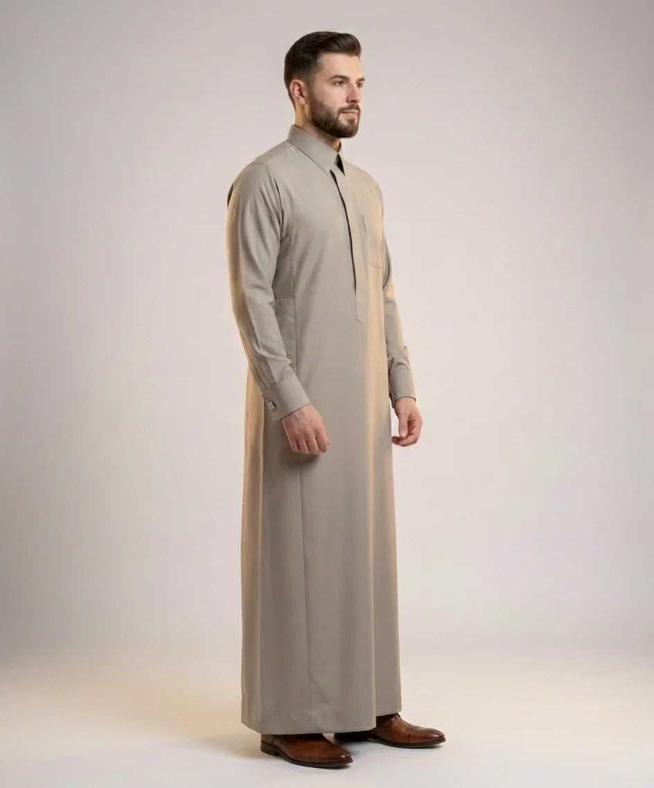 Walking view of Executive Sand Grey Thobe displaying confident movement, executive sophistication, premium tailoring, refined craftsmanship, and luxurious Gulf-inspired formal wear ideal for business meetings, weddings, Eid celebrations, receptions, and prestigious gatherings. إطلالة أثناء المشي لثوب رمادي رملي فاخر تعكس الثقة والرقي والفخامة في المناسبات الرسمية والاحتفالات الراقية.