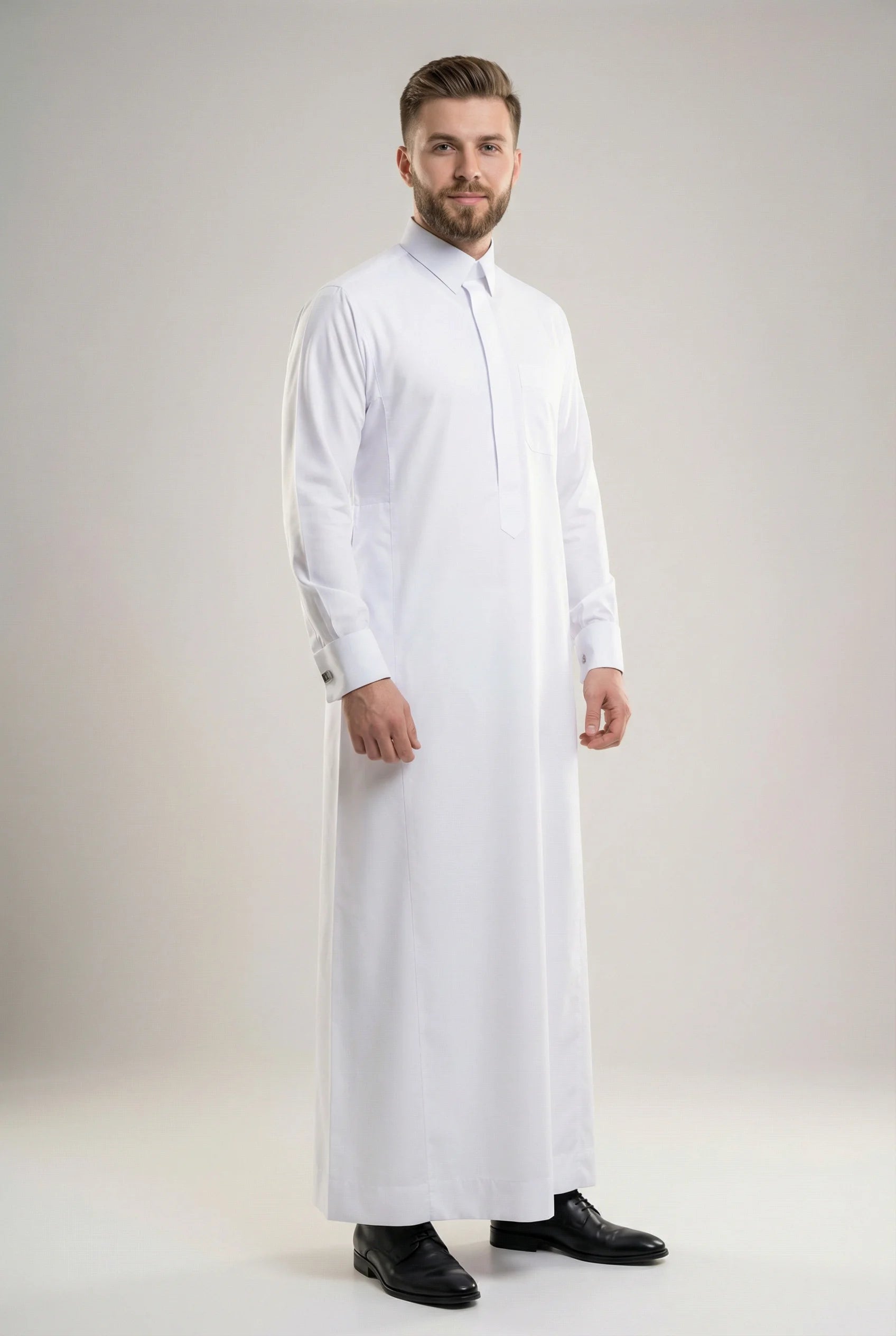 Front view of Imperial White Signature Thobe showcasing a refined executive fit, crisp white fabric, concealed placket, structured collar, premium craftsmanship, and sophisticated formal styling. ثوب أبيض فاخر بإطلالة أمامية يبرز الأناقة الراقية والتفصيل المتقن والحضور المميز للرجل العصري.