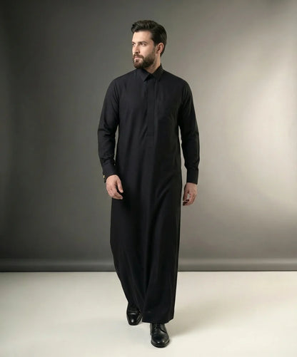 Walking view of Jet Black Executive Thobe displaying confident movement, luxury tailoring, premium comfort, timeless sophistication, and executive formal styling suitable for business settings, corporate functions, and distinguished occasions. إطلالة أثناء المشي لثوب أسود فاحم فاخر تعكس الثقة والهيبة والأناقة التنفيذية مع راحة استثنائية للمناسبات الرسمية والعملية.