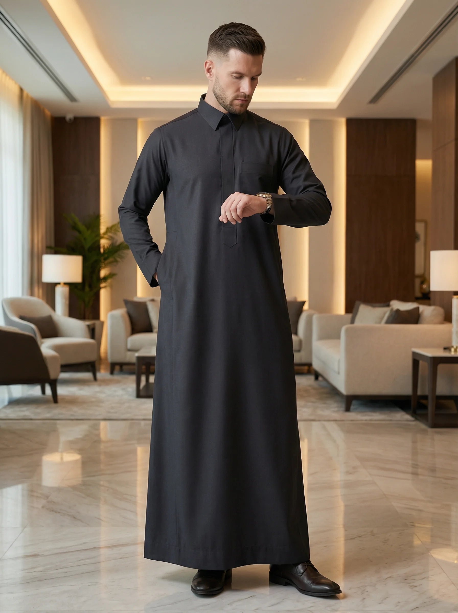 Carbon Black Executive Thobe styled in a luxury interior setting, showcasing confidence, sophistication, and contemporary elegance. Premium Saudi thobe, luxury men's jubba, Islamic menswear, ثوب كربوني أسود فاخر للرجال, ثوب سعودي أنيق, ثوب رجالي رسمي, جلابية رجالية راقية, دشداشة رجالية فاخرة, ملابس إسلامية رجالية, premium modest fashion ideal for professionals, Ramadan, Eid, prayer, family gatherings, and elevated everyday wear.