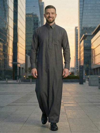 Luxury Charcoal Grey Premium Formal Thobe by Haybah styled in a modern urban business environment, highlighting sophisticated craftsmanship, executive elegance, breathable comfort, and contemporary formal fashion for modern gentlemen. ثوب رمادي فحمي فاخر بإطلالة عصرية في بيئة أعمال راقية يجمع بين الفخامة والراحة والأناقة ليمنح الرجل حضوراً مميزاً في الاجتماعات والمناسبات الرسمية.