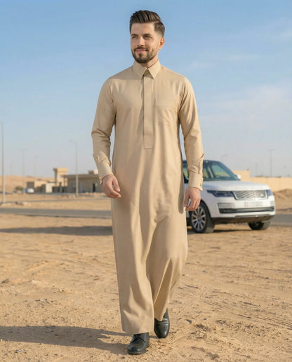Desert Beige Premium Formal Thobe styled in a luxury outdoor desert-inspired setting, combining modern Gulf fashion, premium craftsmanship, breathable comfort, and timeless elegance for sophisticated men. ثوب بيج صحراوي فاخر بإطلالة مستوحاة من أجواء الخليج يجمع بين الفخامة والأناقة الكلاسيكية والراحة ليمنح الرجل حضوراً راقياً ومميزاً.