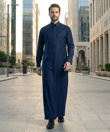 Midnight Navy Executive Thobe styled in a luxurious desert-inspired Gulf setting, showcasing premium craftsmanship, timeless elegance, sophisticated occasion wear styling, and distinguished executive fashion for modern gentlemen seeking refined luxury. ثوب كحلي داكن فاخر بإطلالة مستوحاة من البيئة الخليجية الراقية يجمع بين الأناقة التنفيذية والفخامة العصرية والتميز في المناسبات الرسمية والخاصة.