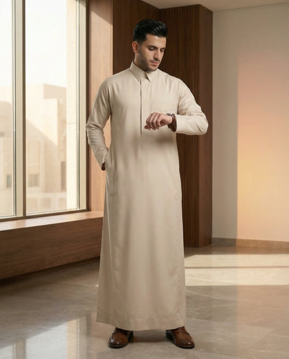 Pearl Beige Classic Thobe styled in a luxury modern interior setting, showcasing premium Islamic menswear with refined elegance, comfort, and timeless sophistication. Luxury Saudi thobe, men's designer thobe, premium jubba, ثوب سعودي فاخر للرجال, ثوب بيج لؤلؤي, ثوب رجالي أنيق, ثوب عربي فاخر, جلابية رجالية فخمة, دشداشة رجالية راقية, ملابس إسلامية رجالية, premium modest fashion designed for professionals, Ramadan, Eid, family gatherings, prayer, and elevated everyday living across Saudi Arabia and the GCC.